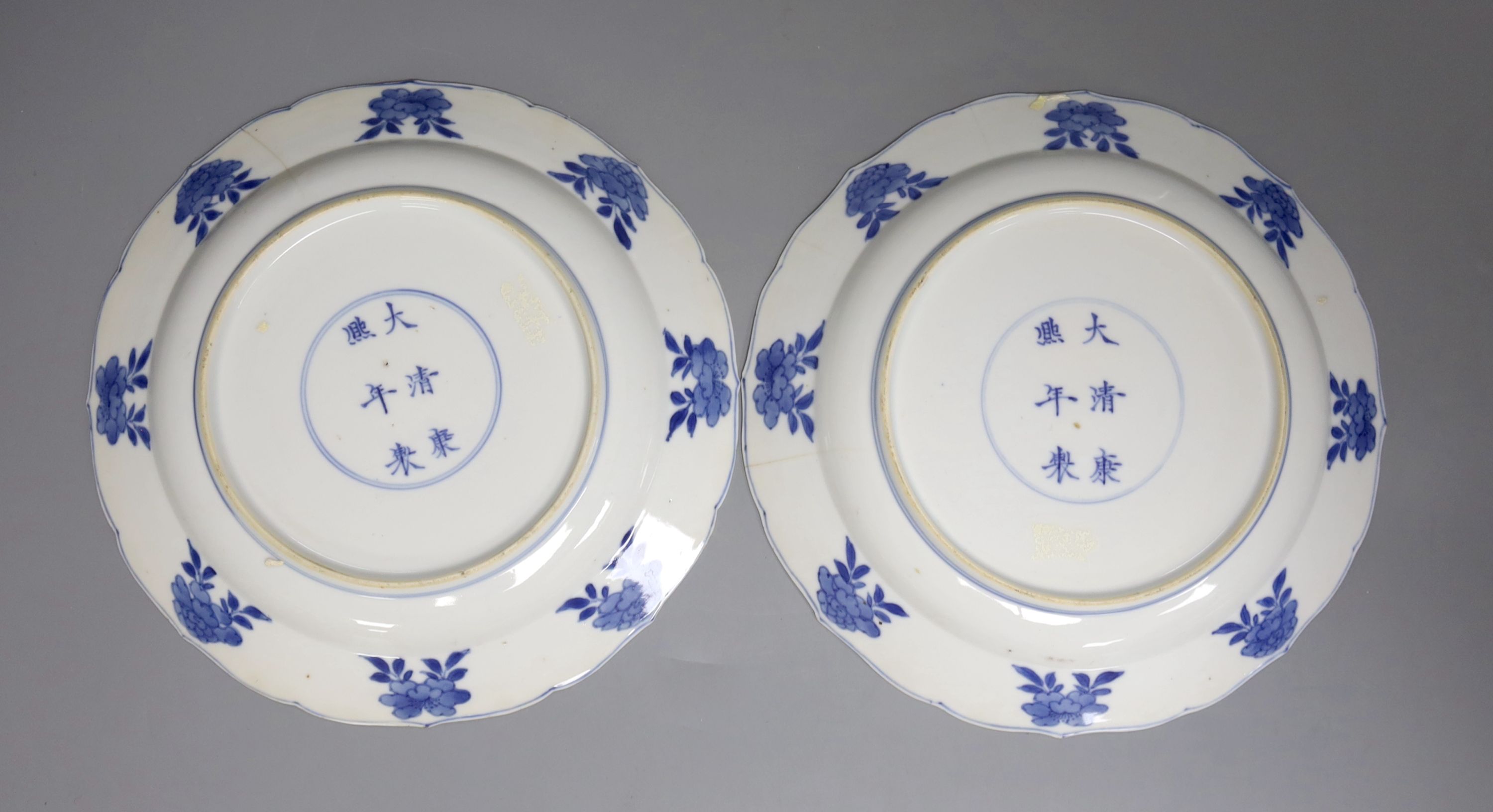 A pair of Chinese blue and white porcelain plates, Kangxi mark and period, with shaped borders and floral motifs, diameter 20cm